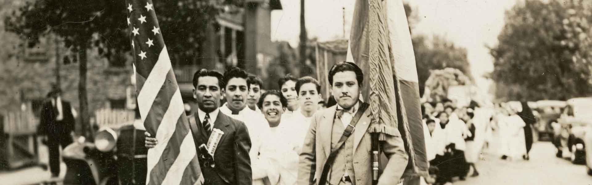 Inaugural mass at Our Lady of Guadalupe, 1942, parade with two male flag-bearers, one with American flag and other with Mexican